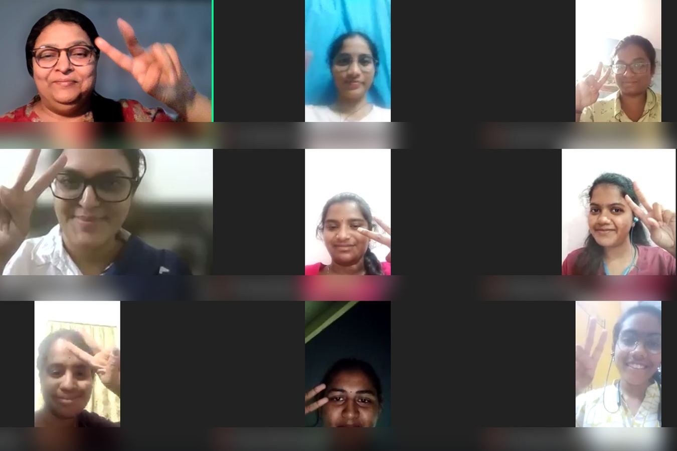 Participants on a video call raising peace signs with Padmini